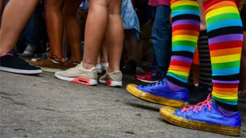 Getty Images A group of people with only their legs showing, including one person with rainbow-coloured socks
