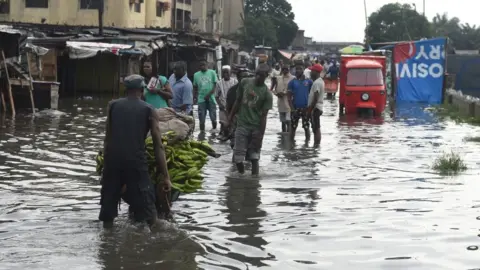 AFP People walk on a flooded road at Okokomaiko in Ojo district of Lagos, on May 31, 2017.