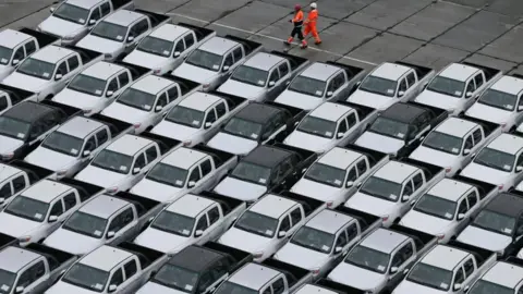 Reuters Workers walk past new Chinese cars unloaded from a ship at a commercial port in Vladivostok, Russia
