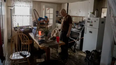 Getty Images Gordon George, of Barre, Vermont, worked with his daughter, Danielle Palmer, of Washington, to survey the damage to his home