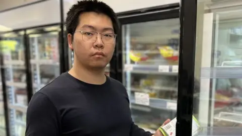 Cheng Gong standing next to freezer