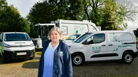 Stuart Walker Councillor Denise Rollo standing in front of Cumberland Council refuse collection vehicles
