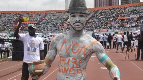 AFP A man painted up at a rally against the candidacy of Alassane Ouattara at a stadium in Abidjan, Ivory coast
