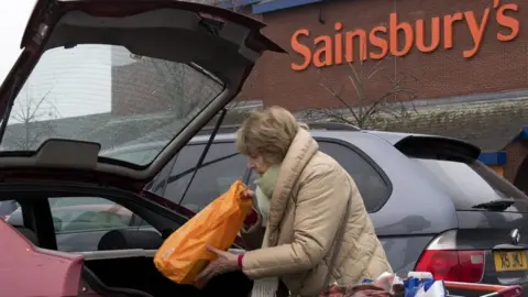 Getty Images Woman loading car in Sainsbury's car park