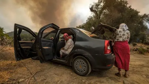 AFP Women in or near car, with smoke behind them