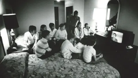 Dick Swanson Germaine’s family in the hotel room watching news of the fall of Saigon