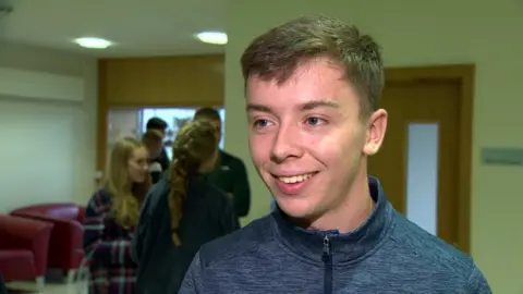 A student is smiling having received his grades