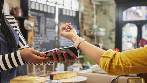 Getty Images Person paying at cafe counter using smart watch