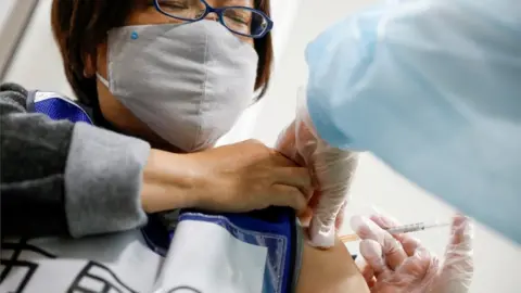 Reuters Japanese woman receiving vaccine jab