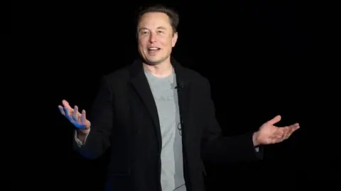 Getty Images Elon Musk presents on stage at a SpaceX event