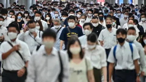 Getty Images Early morning commuters in Tokyo.