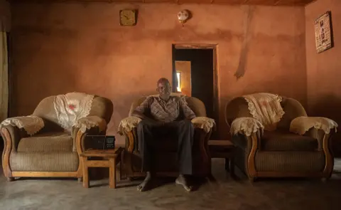 Omoregie Osakpolor Man sitting on a comfortable chair