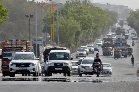 Reuters Traffic moves on a road in a heat haze during hot weather on the outskirts of Ahmedabad, India, May 12, 2022