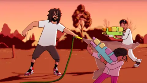 Donald Glover/YouTube J Cole with a hose pipe