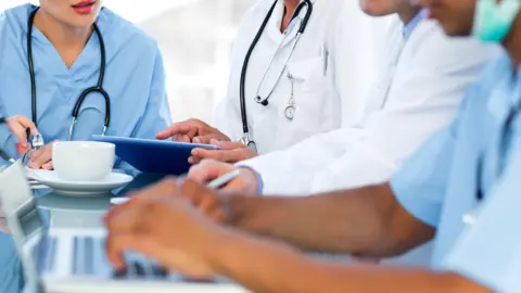 Getty Images Medics in South Africa around a table on which is a cup of tea