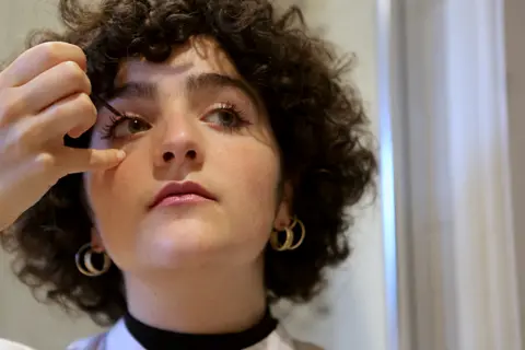 Sophie Wedgwood/BBC Gilda Bruno puts on makeup as she gets ready for an evening out