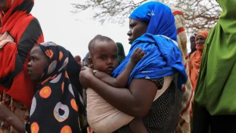 Internally displaced Ethiopians queue to receive food aid in the Higlo camp for people displaced by drought, in the town of Gode, Somali Region