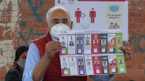 EPA Presidential candidate Carlos Mesa shows the electoral ballot when casting his vote in a precinct in the city of La Paz, Bolivia, 18 October 2020.