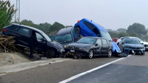 Getty Images Cars piled up due to amudslide following floods in Picuana near Valencia