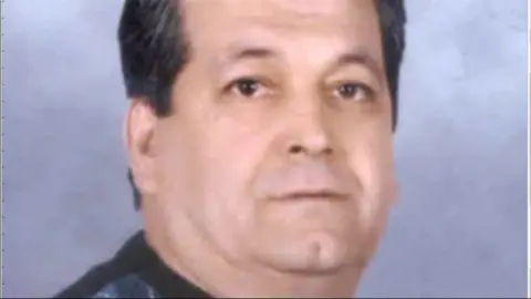 Metropolitan police Ahmet Paytak has short dark hair and is wearing a dark top