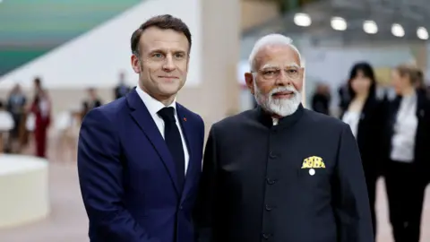 French President Emmanuel Macron shakes hands with Indian Prime Minister Narendra Modi as they arrive to attend the Artificial Intelligence (AI) Action Summit at the Grand Palais in Paris, France, February 11, 2025