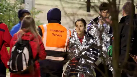 Emergency services attend to people at the scene where multiple people were stabbed on a train in Huntington, Cambridgeshire, on 1 November 2025