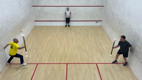 BBC Three men on a squash court playing VX