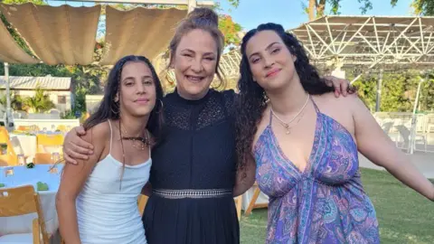 British Israeli Lianne (center) (right) and Yaher (left) standing looking at camera