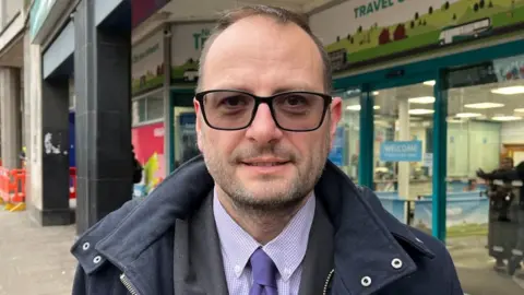 Anthony Carver-Smith stood outside the NCT Travel Centre on South Parade.