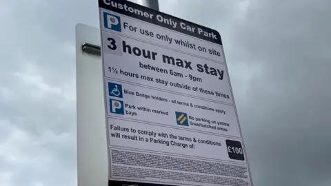 Henry Godfrey-Evans/BBC A parking sign giving details of the parking terms and conditions. It has about a dozen lines of smallprint at the bottom.