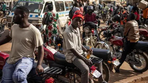 AFP/Getty Images Boba boda riders by the side of a road in Kampala 