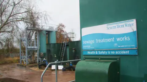 Severn Trent A waste water plant. A large blue and white sign advertising Severn Trent's sewage treatment works hangs on the side of the building.