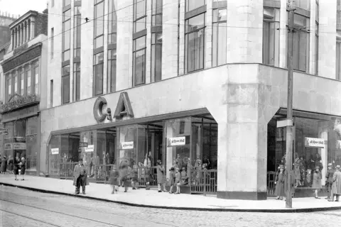 streets-UK A black and white image of a large shop in the 1930s or 40s. Various people are walking by and a large C & A sign is above the shop windows 