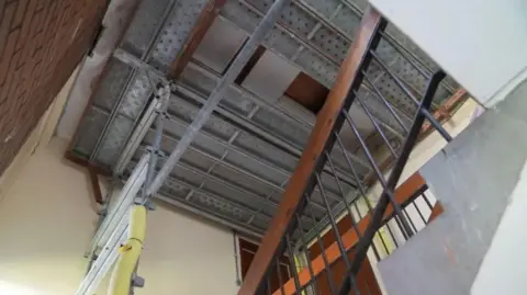A steel structure attached to the interior roof of a tenement building