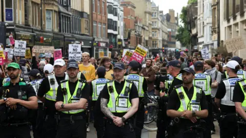 PA Police officers stand guard as protesters take part in an "All Out Against Tommy Robinson" protest organised by groups including Stand Up to Racism Oxford in Oxford city centre