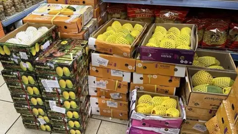 Stacks of boxes of mangoes in a grocery shop