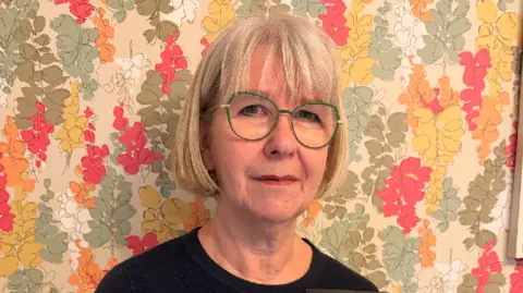 BBC Alexandra Whittaker holding a picture of her parents on their wedding day