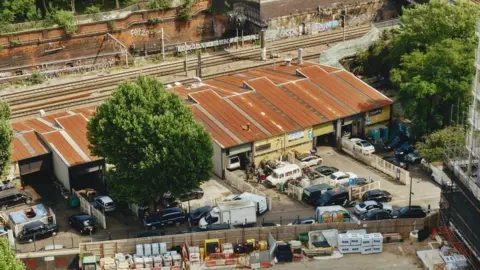 Andrew Goss An aerial view of a row of mechanic workshop buildings.