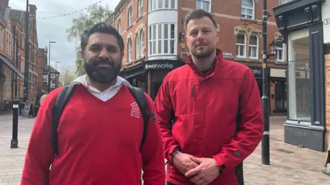 Two men in red city warden uniforms