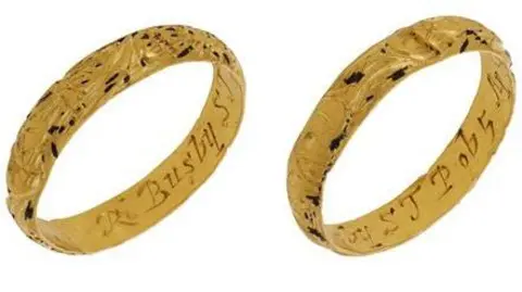 Noonans Two images of a gold ring can be seen in this composite image. On the left, a gold ring has the word 'Busby' engraved inside it and on the right there is more engraved lettering, although it is not clear what this says.