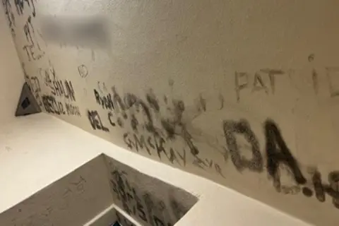 HMIPS Graffiti covering the walls of a cell in a court custody unit