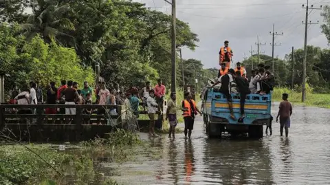 Getty Images Los voluntarios intentan hacer fila antes de entregar un paquete de alimentos de socorro en Feni, Chittagong, Bangladesh, el 26 de agosto de 2024.