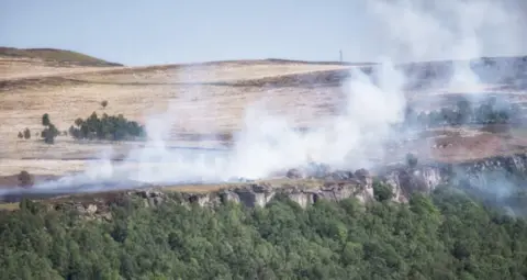 VILLAGER JIM Smoke from a fire rising hillside landscape 