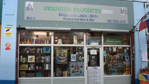 Metropolitan Police The facade of the Original Products store - with the wording Religious Artefacts: Herbs and Products from Haiti and USA on the front. The windows and doors are full of paraphernalia.