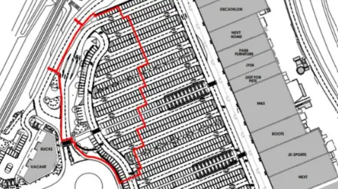 An overhead drawing of a retail park. There is a red perimeter drawn around car parking spaces