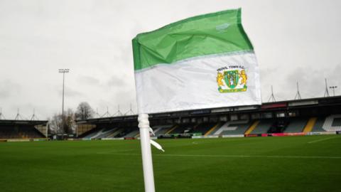 A Yeovil Town Football Club flag in front of a football pitch