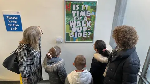 Bedfordshire Hospitals NHS Foundations Trust School children looking at art on the wall of a Bedfordshire hospital