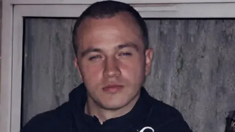 Family photo A man with short dark hair is seen looking at the camera