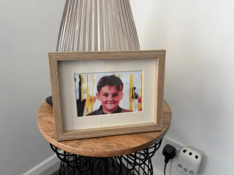 A picture of Kaylan Hippsley in a photo frame on a table.
