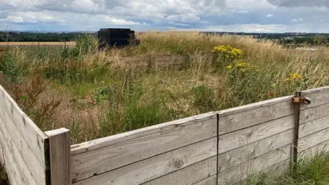 A fenced and grassed area around the top of a 1950s nuclear bunker